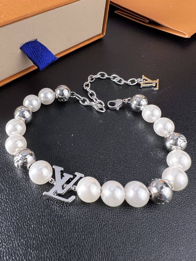 Lv Monogram Pearls 手链为亮泽金属串珠镂刻 Monogram 图案，与珍珠般莹润的串珠和 Lv 串珠共同汇聚视觉焦点，搭配可调节链条和 Lv