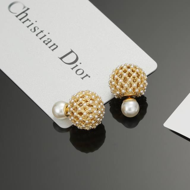 迪奥字母cd珍珠耳环 这款 Dior Tribales 耳环在 Dior 标志性款式的基础上演绎出新的风格。白色树脂珠饰悬挂着银色饰面金属字母“D.I.O.R.