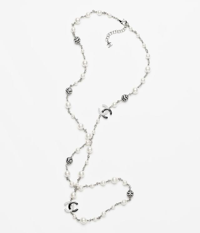 香奈儿项链热销爆上新 Chan 23 黑白水钻双c珍珠毛衣链 这款项链设计精美，优雅而华丽。多个珍珠和金属装饰相互交错，营造出一种高贵而精致的氛围。项链的长度适
