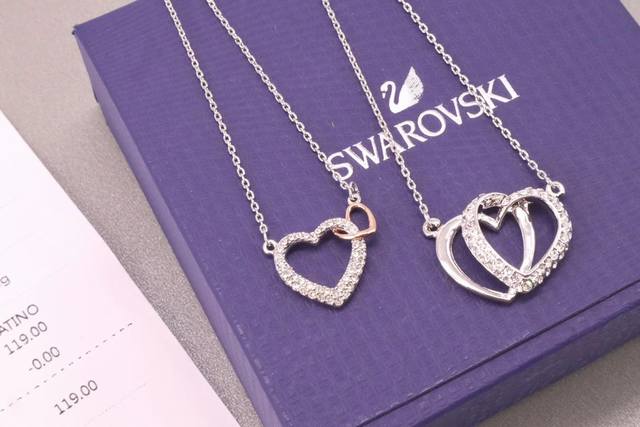 Swarovski 新款双心锁骨项链 心心相印的优美设计，象征着永恒不变的爱，缀有精致讲究的透明密镶仿水晶，镀白金色金属，增添时尚妩媚的气息。