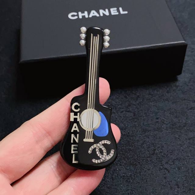 Chanel小香 最新款高版本进口亚克力吉他镶钻彩色香奈儿胸针，是最懂女人的饰物。那些倾注了全部心血去做自己的女人，往往更珍惜胸针的意义。香奈儿女士把胸针别在帽